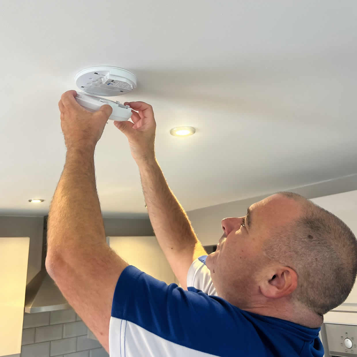 Smoke alarm being installed on a ceiling in Lowestoft
